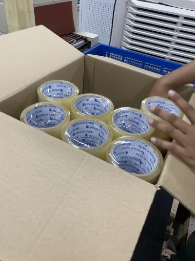 ม้วนเทปใสตราหงส์เรียงเต็มกล่องกระดาษระหว่างแพ็กใส่ลัง — SWAN TAPE โรงงานผลิตเทปกาว
