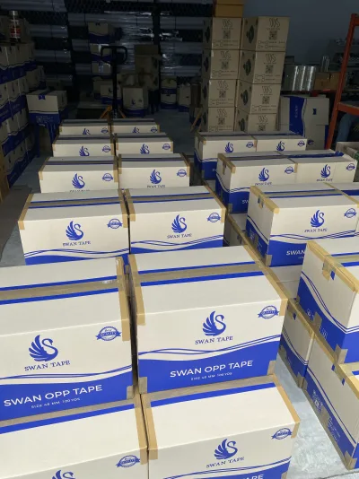 ลังเทป SWAN TAPE และ WS OPP TAPE วางบนพาเลทในคลังเดียวกัน — SWAN TAPE โรงงานผลิตเทปกาว