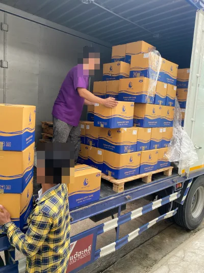 พนักงานสองคนช่วยกันยกลังเทปกาว SWAN OPP TAPE ขึ้นเรียงบนพาเลทในตู้รถบรรทุกที่จอดรับสินค้า — SWAN TAPE โรงงานผลิตเทปกาว