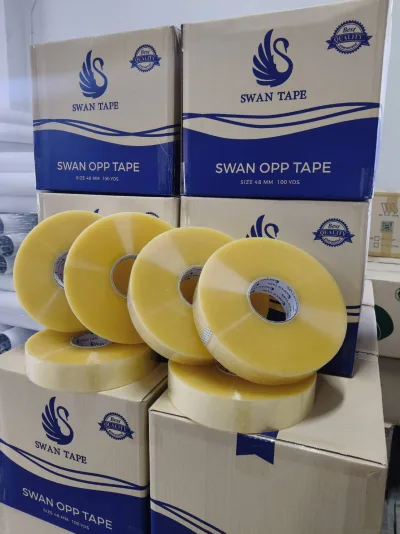 กล่องเทปสวอนซ้อนเป็นชั้นในคลัง มีม้วนเทปใสวางเรียงอยู่ด้านหน้า — SWAN TAPE โรงงานผลิตเทปกาว