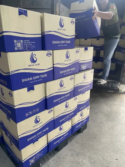 พนักงานยกลังเทปสวอนขึ้นรถ มีลังเรียงเต็มพาเลทอยู่ด้านหน้า — SWAN TAPE โรงงานผลิตเทปกาว