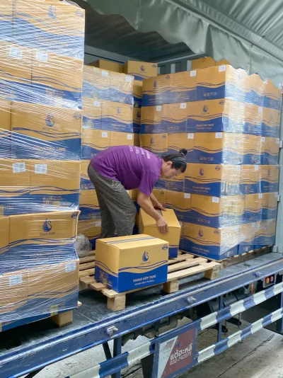 พนักงานวางกล่องเทปลงบนพาเลทไม้ในตู้รถบรรทุกที่จัดของเกือบเต็ม — SWAN TAPE โรงงานผลิตเทปกาว