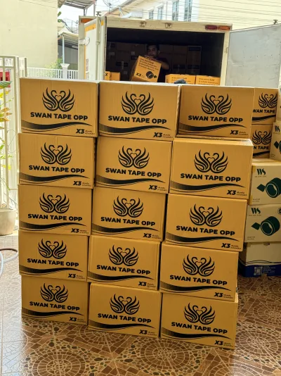กล่องเทป SWAN TAPE OPP ซ้อนเรียงรอขนขึ้นรถบรรทุกที่จอดเปิดท้าย — SWAN TAPE โรงงานผลิตเทปกาว