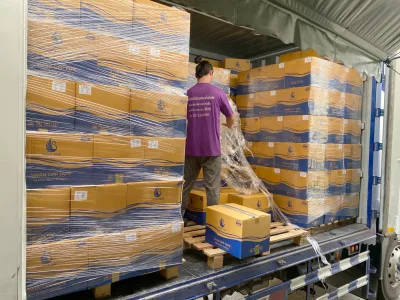 พนักงานพันฟิล์มยืดรอบพาเลทกล่องเทปในตู้รถบรรทุกก่อนออกส่ง — SWAN TAPE โรงงานผลิตเทปกาว