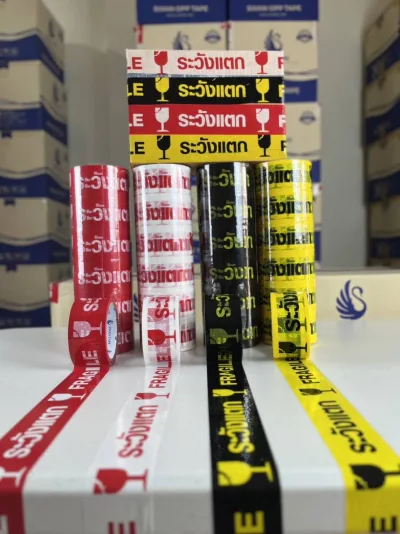 แถวม้วนเทประวังแตกดึงปลายเทปออกมา วางหน้ากองลังสินค้าในคลัง — SWAN TAPE โรงงานผลิตเทปกาว
